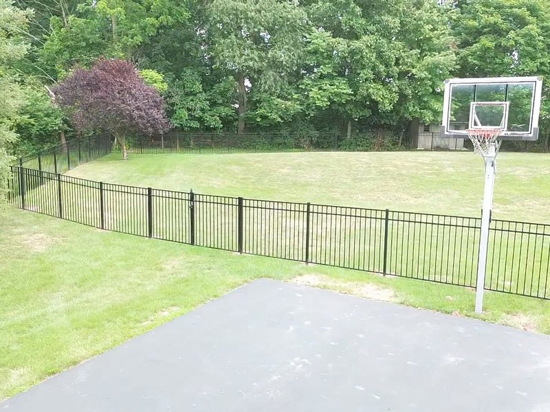Fence run installed along a property line with posts set plumb in poured footings